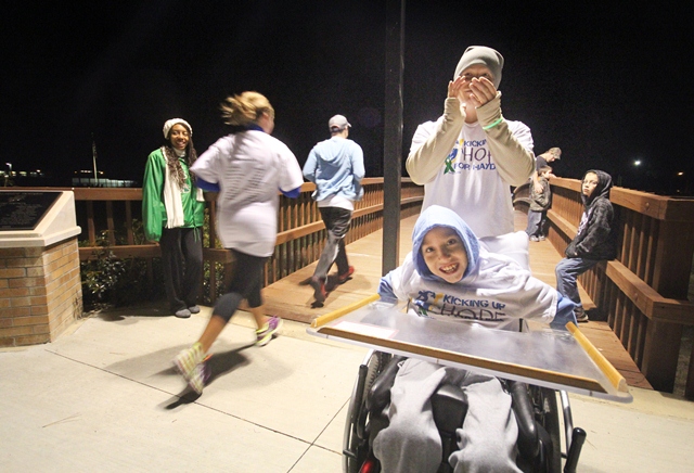 Hayden Cain Minor, 9 of Camden, and his stepfather, Paul Pharr, cheer on runners