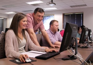 Ronnie Watson, assistant professor of management, helps student Sarah Clayton in SAU’s first SAP ERP course offered this spring.